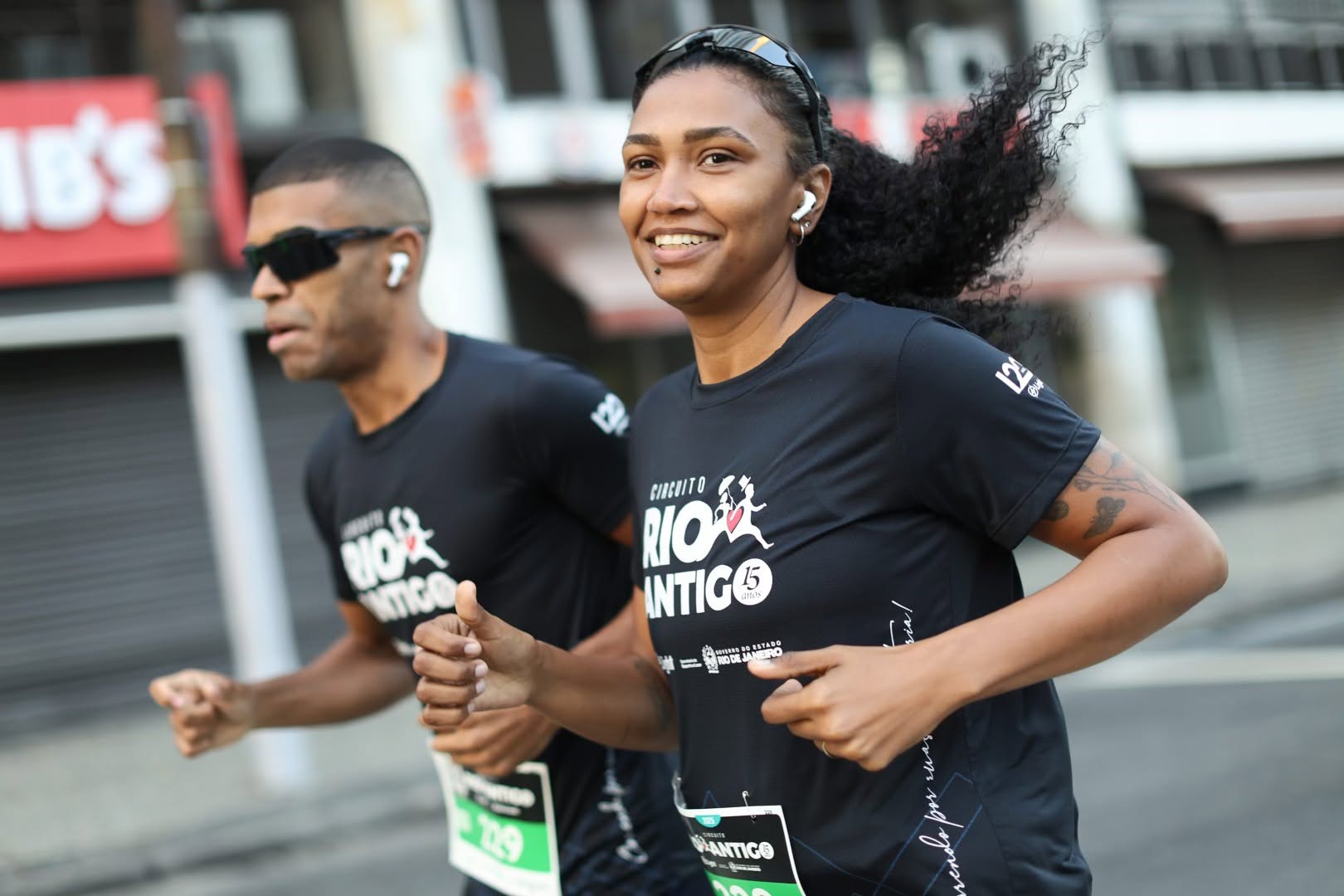 Atletas comemorando sob o pórtico de chegada do Circuito Rio Antigo